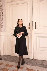 a lady in a black jacket and a black skirt